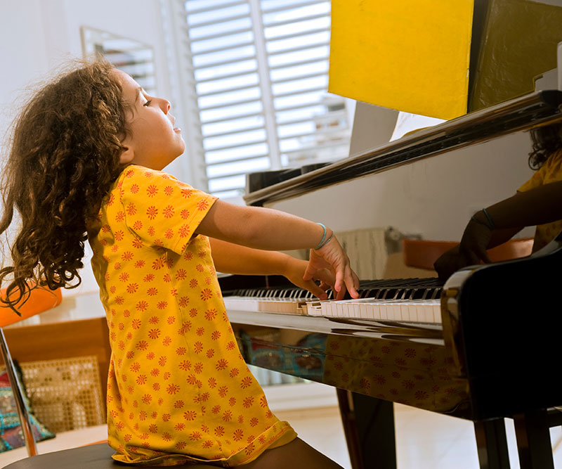 Child joyfully playing piano