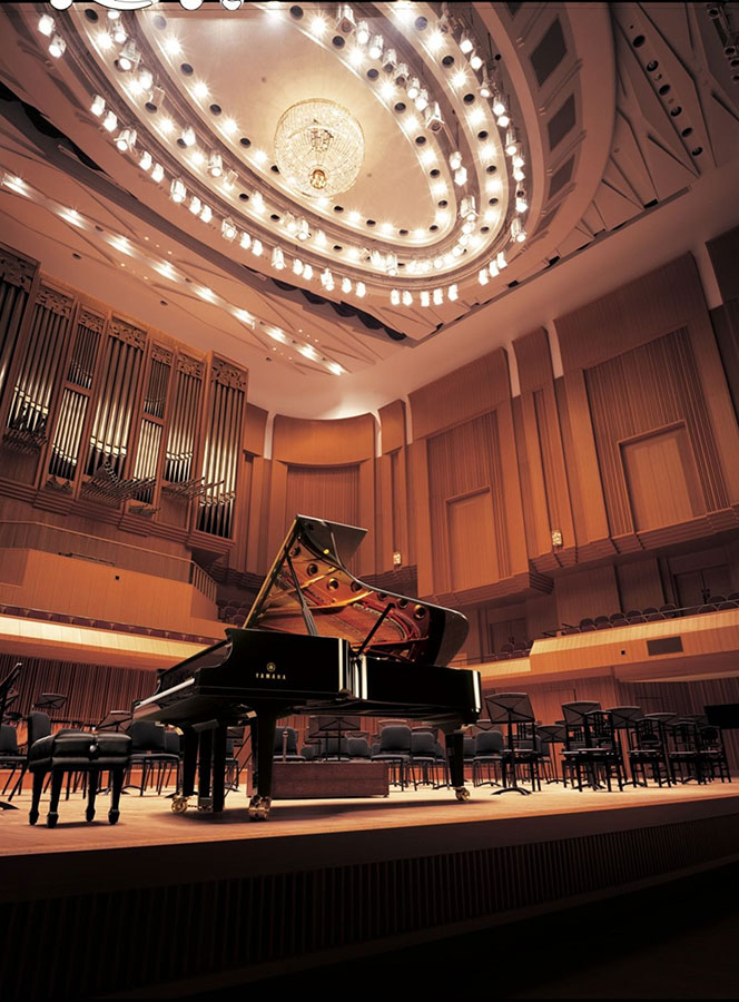 Grand piano in concert hall with a chandelier overhead