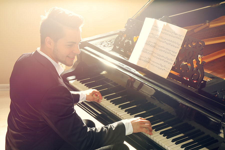 Professional piano player performing on a grand piano